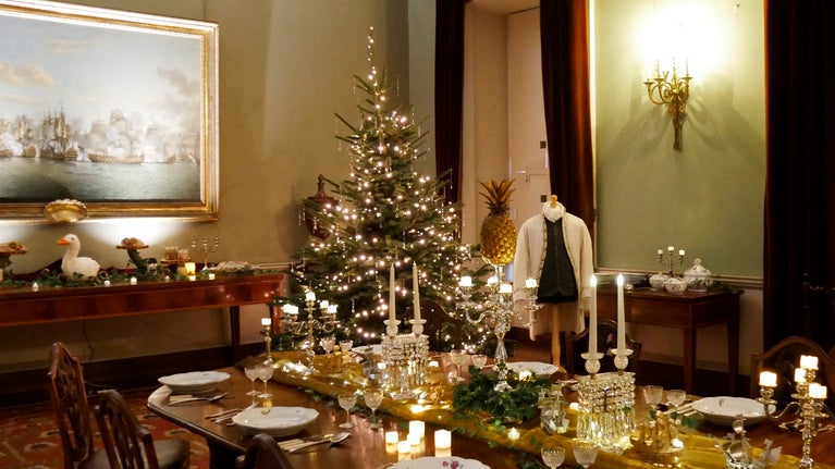 The dining room at Berrington Hall decorated for a truly Georgian Christmas with a huge Christmas Tree covered in twinkling lights and cut crystal glassware on the table.